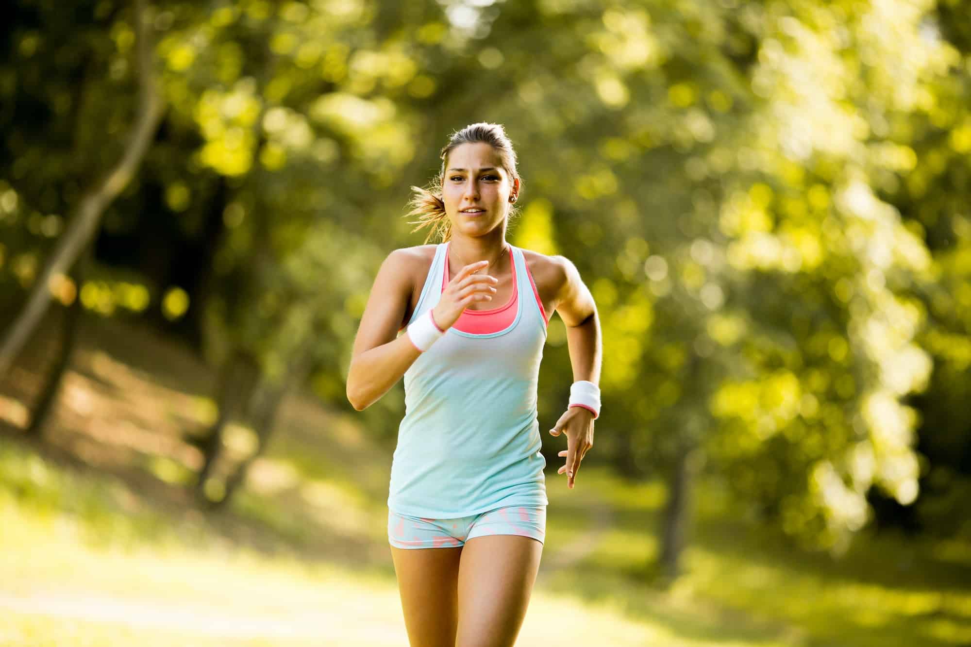 Junge frau joggt durch den Wald